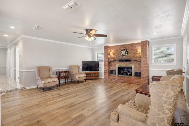 104 W Perry St, Frankston, TX 75763 - living room with light wood-type flooring, a brick fireplace, a ceiling fan, ornamental molding, and recessed lighting