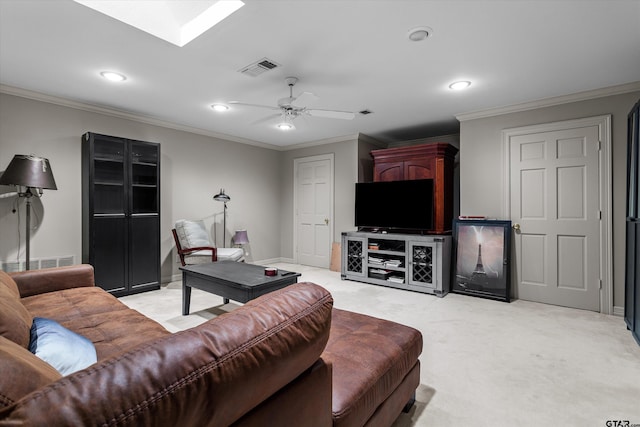 living room featuring a skylight, light colored carpet, ceiling fan, and crown molding