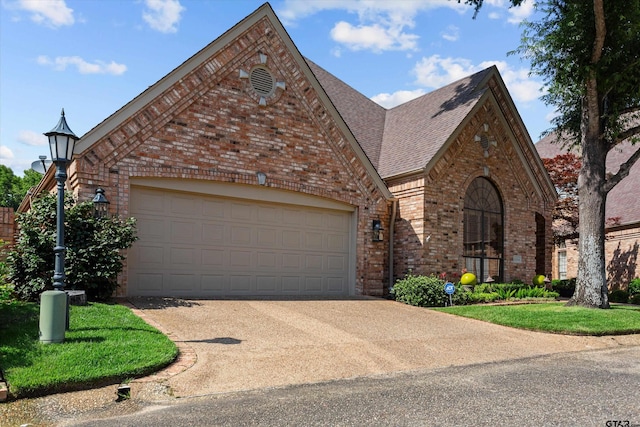 english style home featuring a garage