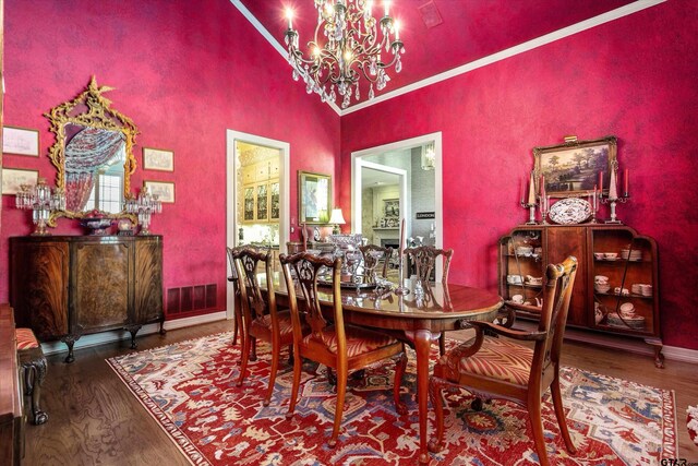 dining space with hardwood / wood-style floors, a chandelier, and high vaulted ceiling