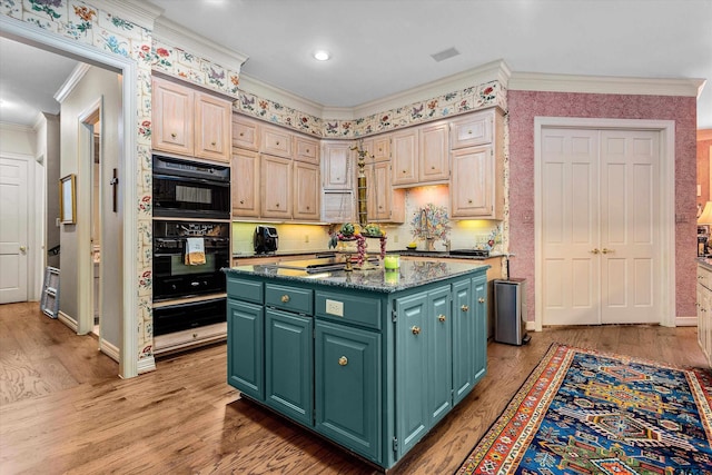 kitchen with ornamental molding, gas cooktop, light hardwood / wood-style floors, double oven, and a center island