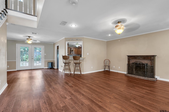 unfurnished living room with french doors, dark hardwood / wood-style flooring, a brick fireplace, and crown molding