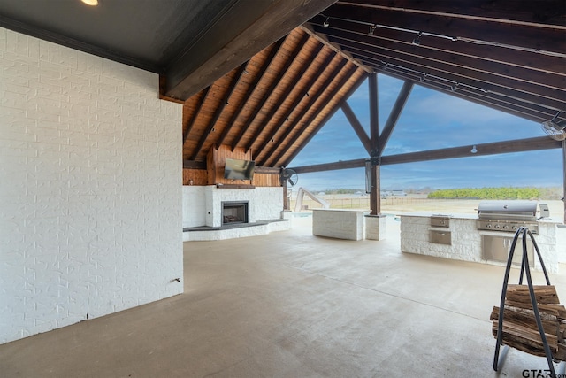 view of patio with exterior kitchen, area for grilling, and a fireplace