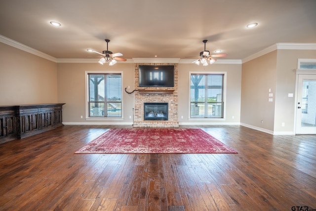 unfurnished living room featuring ceiling fan, dark hardwood / wood-style flooring, ornamental molding, and a healthy amount of sunlight