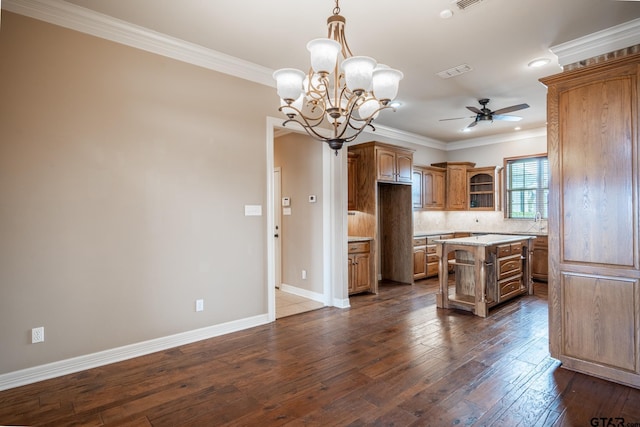 kitchen featuring decorative light fixtures, ceiling fan with notable chandelier, crown molding, and a center island