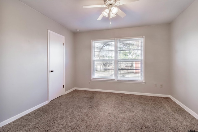 carpeted empty room with ceiling fan and baseboards