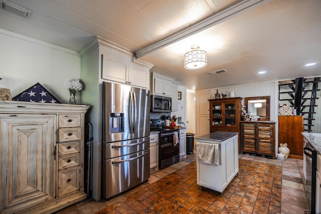 kitchen featuring appliances with stainless steel finishes, a kitchen island, and white cabinetry