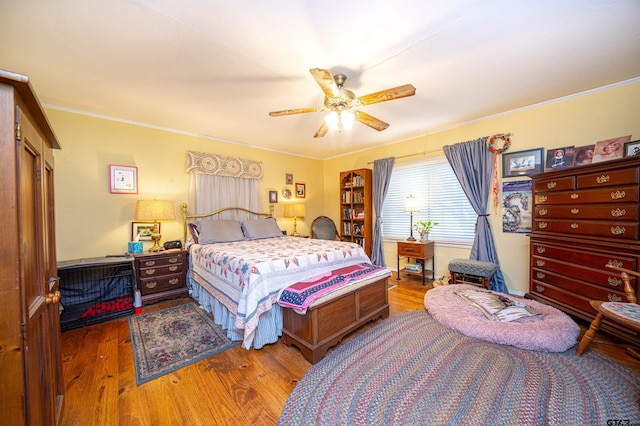 bedroom featuring ceiling fan, hardwood / wood-style flooring, and ornamental molding