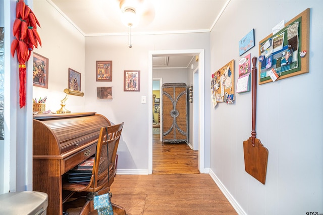 home office with crown molding and light hardwood / wood-style floors