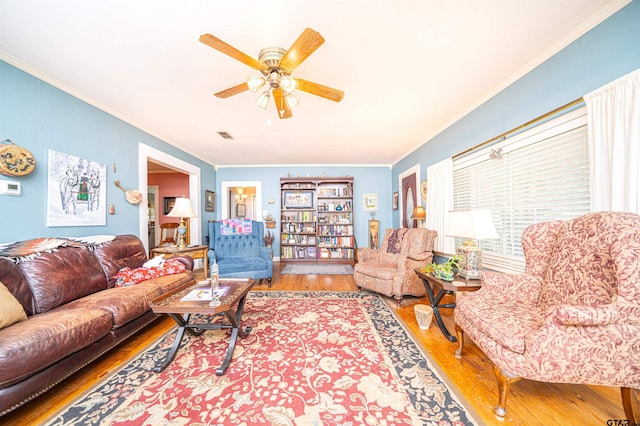 living room featuring crown molding, hardwood / wood-style flooring, and ceiling fan