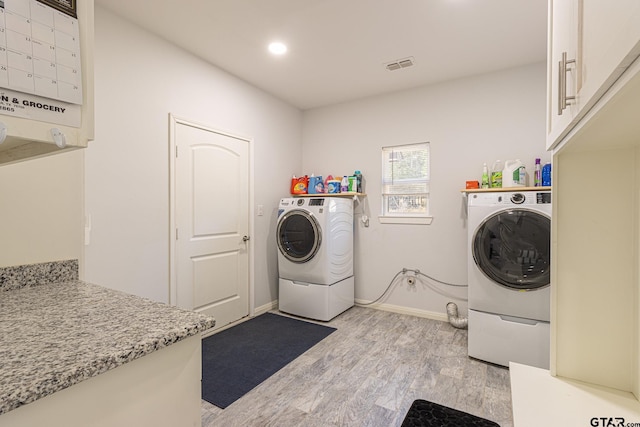 laundry room with washer and clothes dryer and light wood-type flooring