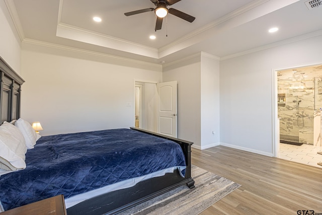 bedroom featuring ensuite bath, a raised ceiling, ceiling fan, crown molding, and hardwood / wood-style floors