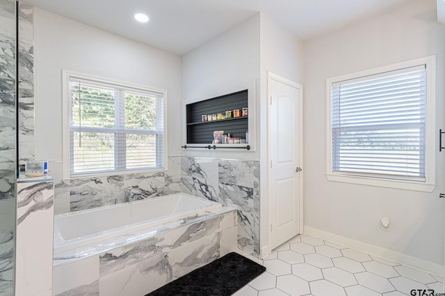 bathroom with a relaxing tiled tub