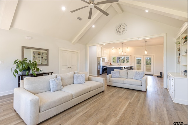 living room with light wood-type flooring, ceiling fan, sink, high vaulted ceiling, and beamed ceiling