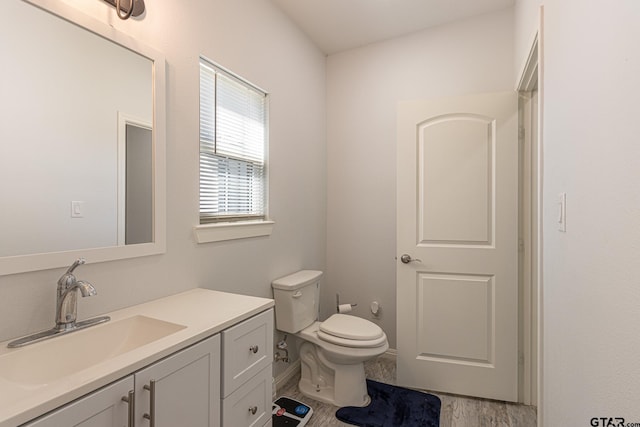 bathroom with hardwood / wood-style flooring, vanity, and toilet