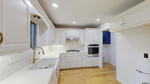 2505 Merry Ln, Tyler, TX 75701 - kitchen featuring appliances with stainless steel finishes, under cabinet range hood, backsplash, white cabinets, and recessed lighting