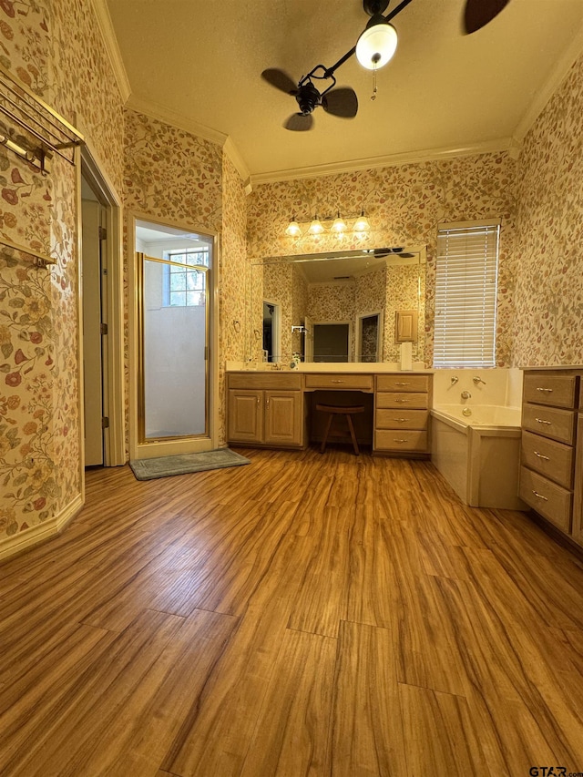 bathroom with hardwood / wood-style floors, a bathtub, ornamental molding, vanity, and ceiling fan