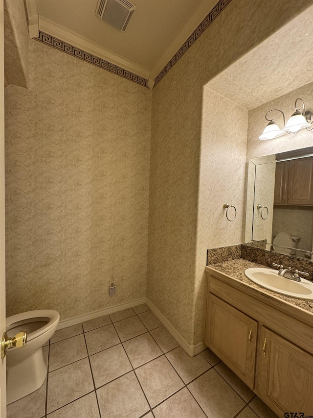 bathroom featuring tile patterned flooring, vanity, ornamental molding, and toilet