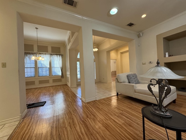 tiled living room featuring crown molding and a chandelier