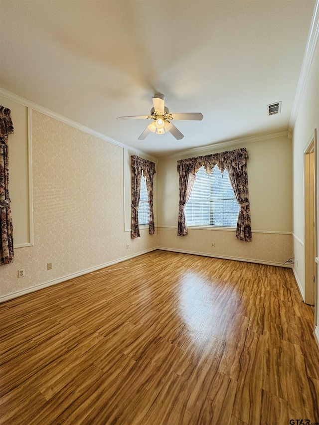 spare room featuring hardwood / wood-style flooring, ornamental molding, and ceiling fan