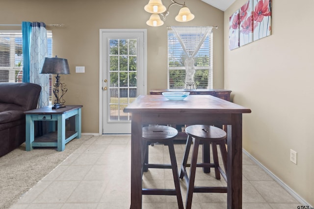 tiled dining space with a chandelier and lofted ceiling