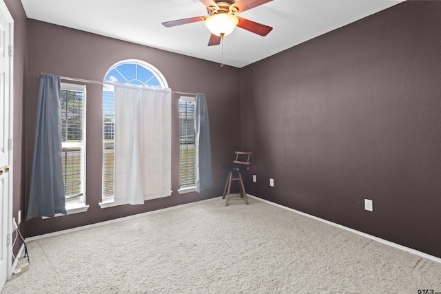 carpeted empty room featuring ceiling fan