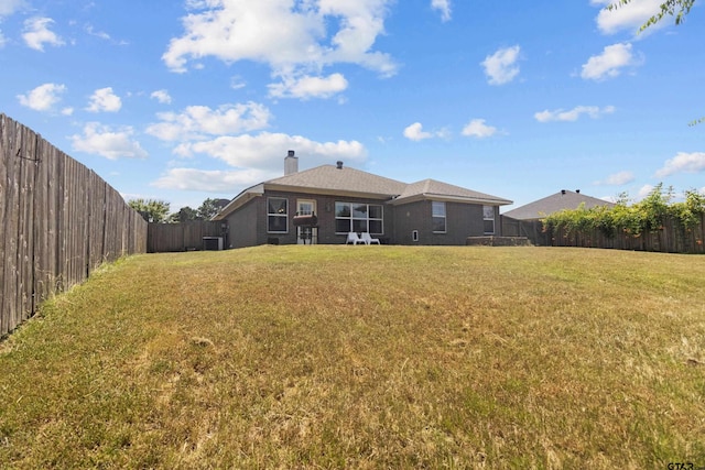 back of property with cooling unit and a lawn