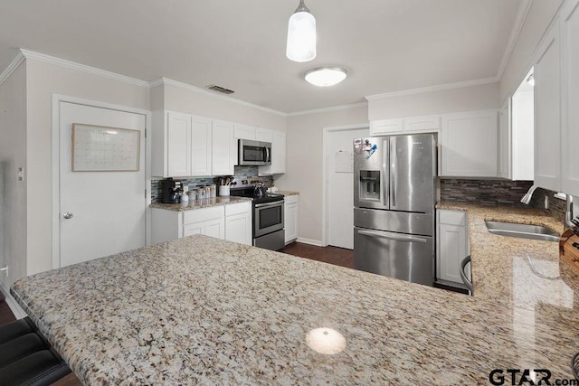 kitchen with a sink, stainless steel appliances, white cabinets, a peninsula, and visible vents