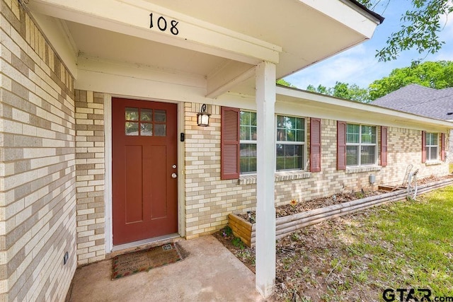 property entrance featuring brick siding