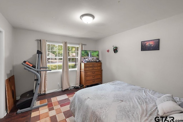 bedroom with baseboards and wood finished floors