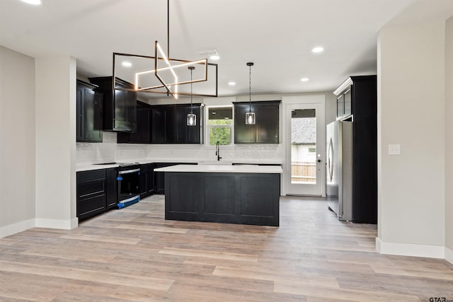 kitchen with a kitchen island, backsplash, pendant lighting, and stainless steel appliances