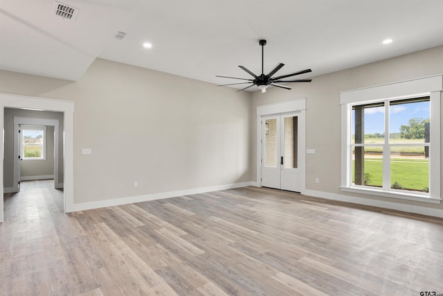 empty room with ceiling fan, french doors, and light wood-type flooring