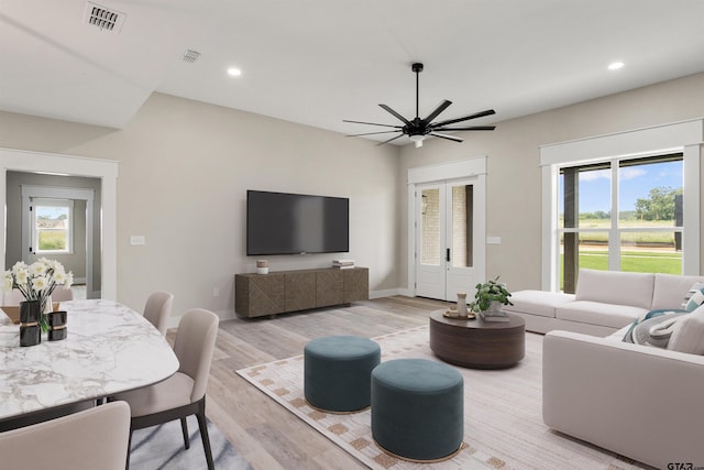 living room with ceiling fan, french doors, and light wood-type flooring