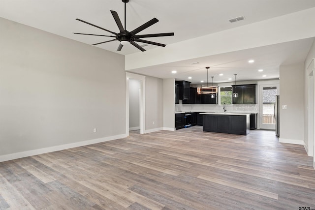 unfurnished living room with hardwood / wood-style flooring and ceiling fan