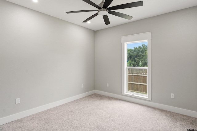 unfurnished room with ceiling fan and carpet