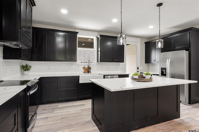 kitchen with decorative light fixtures, sink, electric range, and light wood-type flooring