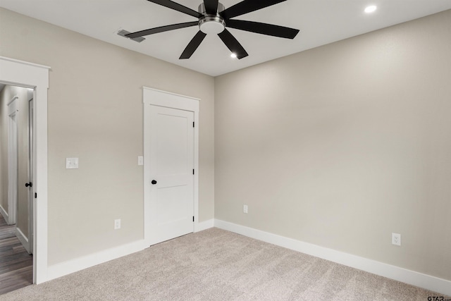 unfurnished room with ceiling fan and carpet