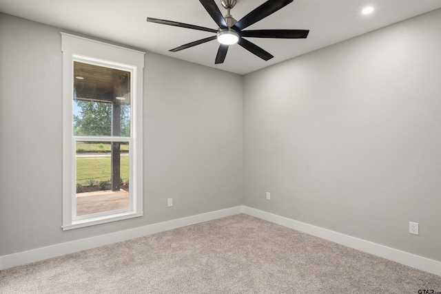 spare room with ceiling fan and light carpet