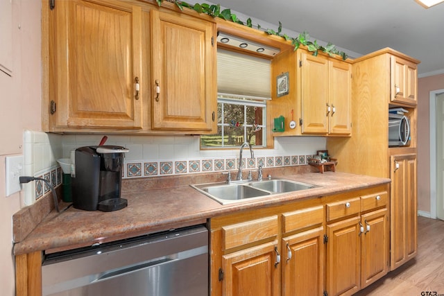 kitchen with tasteful backsplash, appliances with stainless steel finishes, sink, and light hardwood / wood-style flooring