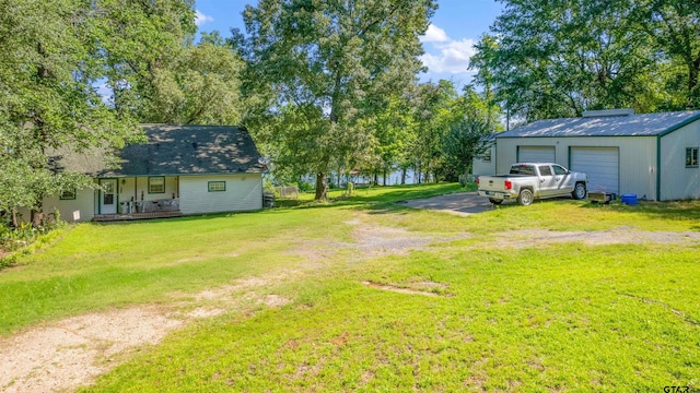 view of yard with a garage and a porch