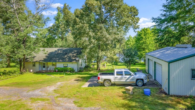 view of yard featuring an outbuilding, a porch, and a garage