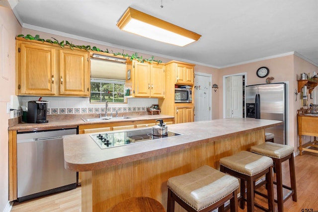 kitchen with stainless steel appliances, a kitchen breakfast bar, and light wood-type flooring