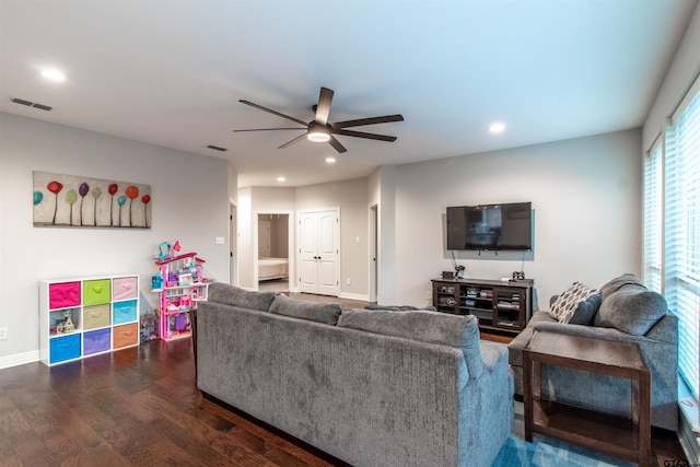 living room featuring dark wood-type flooring and ceiling fan