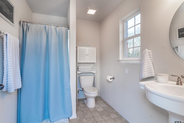 bathroom with a shower with curtain, sink, tile patterned flooring, and toilet