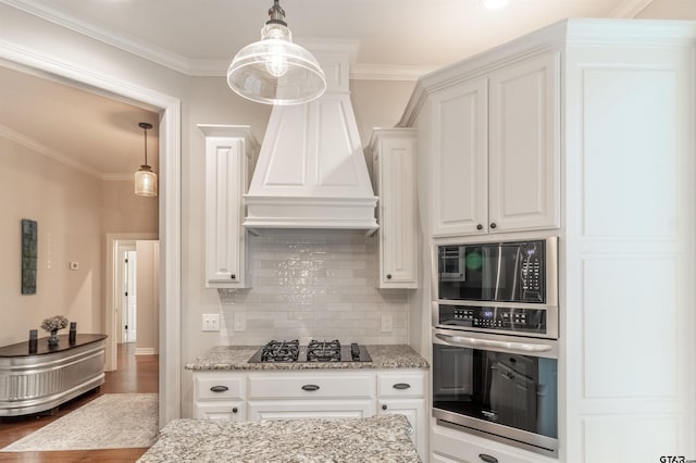 kitchen with light stone counters, gas stovetop, ornamental molding, white cabinets, and stainless steel oven