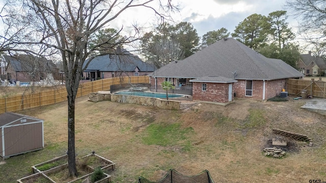 exterior space with cooling unit, a fenced in pool, and a storage unit