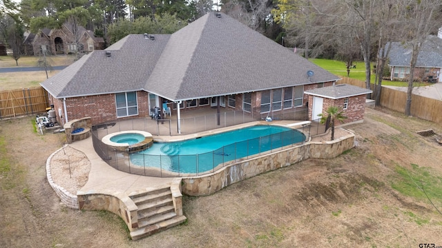 view of pool featuring an in ground hot tub, an outdoor structure, and a patio area