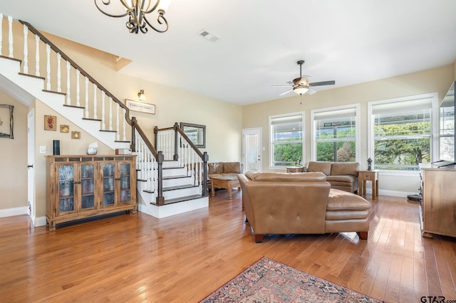 living room with wood-type flooring and ceiling fan with notable chandelier