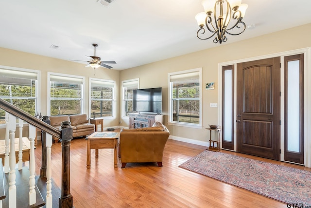 entryway featuring ceiling fan with notable chandelier and light hardwood / wood-style flooring