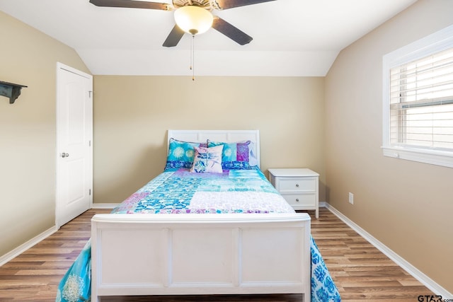 bedroom featuring ceiling fan, wood-type flooring, and vaulted ceiling